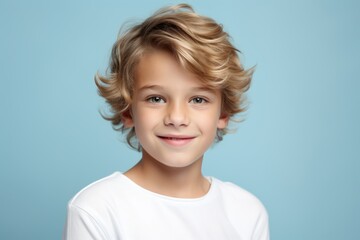 Wall Mural - Portrait of a cute little boy with blond hair on a blue background