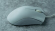 White PC mouse on a gray background with concrete texture