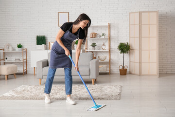 Wall Mural - Young woman mopping floor in living room