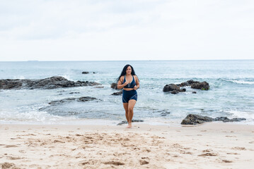 Fitness woman, athlete, doing exercises on the beach running towards the camera.