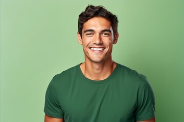portrait of happy young man in green t-shirt over green background