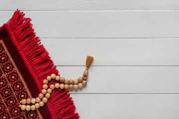 Wall Mural - Prayer mat and beads for Ramadan on white wooden background