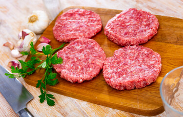 Wall Mural - Cooking ingredients, raw burger cutlets on wooden board