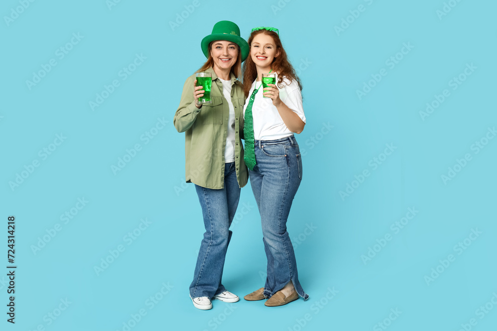 Beautiful women with beer on blue background. St. Patrick's Day celebration