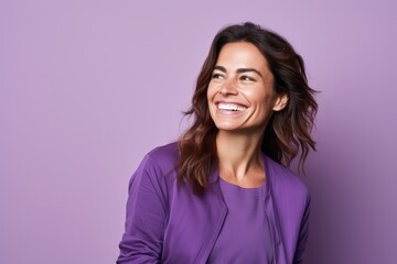 portrait of a beautiful young woman smiling on a purple background.