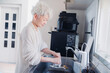 キッチンで洗い物をするシニア女性