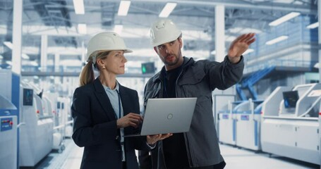 Aufkleber - Caucasian Male Engineer and a Female Technician Having a Conversation and Using Laptop Computer. Specialists Monitoring, Analyzing Conditions at a Modern Electronics Factory with Heavy Machinery