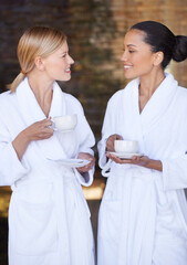 Spa, friends and women drinking coffee for health, wellness and luxury skincare treatment for body. Girls, tea cup and happy people in salon together for beauty in bathrobe, relax and diversity