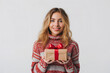 © youriy - woman in a red patterned sweater holding a gift box with a red ribbon smiling at the camera