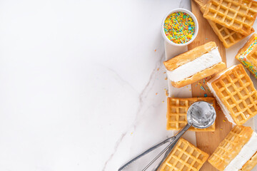 Waffle ice cream sandwiches. Tasty ice cream with fluffy belgian waffles and sugar sprinkles, Summer delicious tasty dessert, on white background with ice cream spoon