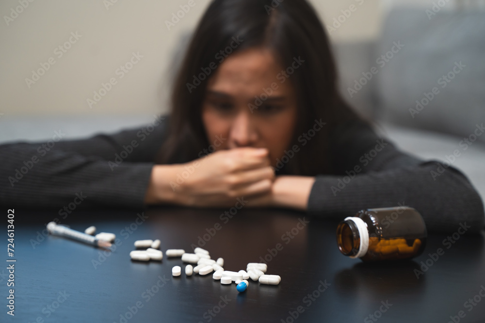 Anti drug, drug addict asian young woman, girl hand reaching for syringe, medicament with narcotic on table at home, abuse overdose. Sick pain of health, unhealthy people. Suicide depressed or despair