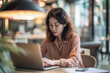 © GustavsMD - Focused Professional at Work. Asian businesswoman concentrating on laptop in modern office