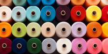 A Large Collection Of Threads Is Shown With The Word Needle On The Front. Colorful Spools Of Thread In Textile Factory.
