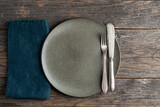 Fototapeta Desenie - Empty vintage plate and cutlery silverware and linen table napkin on a wooden table background. Top view, copy space