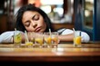woman slumped over bar with empty glasses around her