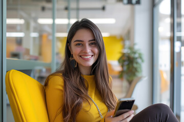 Wall Mural - Beautiful Latin woman holding smartphone and sitting in an office