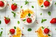 Strawberry and Orange Yogurt Panna Cotta Flatlay. Elegant flatlay of panna cotta with strawberries, orange slices, and mint leaves on white tiled background.

