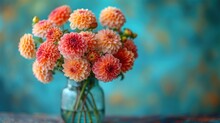  A Vase Filled With Lots Of Pink And Orange Flowers On Top Of A Blue And Green Tableclothed Tablecloth With A Blue Wall Behind The Vase Is Holding A Bunch Of Pink And Orange Flowers.