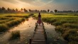 Woman walking on wooden bridge over rice field at sunset in Bali, Indonesia