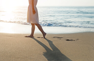 Wall Mural - Woman legs walking on beach.