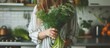 A young woman holds a vase with fresh dill and fennel in her kitchen, showcasing homegrown greens.