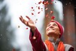 solo person tossing red petals in the air, with a bokeh effect