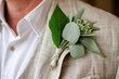 simple green leaf boutonniere on a mans linen jacket, natural light