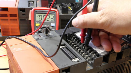 Wall Mural - an electrical engineer measures the voltage on the control system. soft focus, blurred background. p
