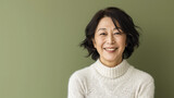 Fototapeta  -  Happy Asian Woman. Portrait of Beautiful Older Mid Aged Mature Smiling Woman Isolated on Olive Green Background. Anti-aging Skin Care Face Beauty Product. Banner with Copy Space.