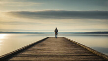 Person Standing Alone On A Dock Looking Out Over The Vast Ocean Landscape