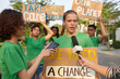 © DragonImages - Eco activist answering questions of journalists when protesting with placard