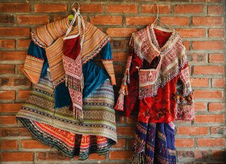 Colorful traditional clothes hanging on brick wall