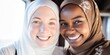 portrait of happy muslim women in hijab looking at camera at home