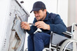 disabled working man plumber repairs a washing machine in laundry