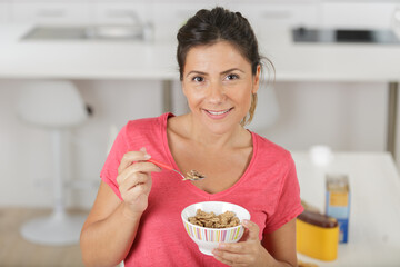 woman close up eating oat and fruits bowl for breakfast