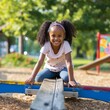 A young girl happily plays on a seesaw in the park, her bright smile and playful energy capturing the essence of carefree childhood