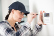© auremar - female technician installing security system using screwdriver