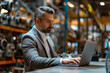 © Dzmitry - Focused businessman using laptop in factory