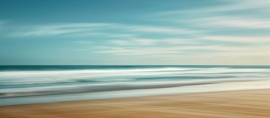 Sticker - The blurry effect in the photo is due to a slow shutter speed capturing the movement of the sea and beach.