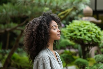 Wall Mural - Woman with dark brown curly hair meditating in a peaceful zen garden