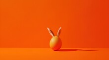  An Orange Background With A White Rabbit's Head Sticking Out Of The Top Of A Yellow Egg On The Floor.