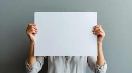 A person stands in front of a wall, adorned in striking clothing, holding a blank sign waiting to be filled with the art of their own design