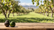 Empty wooden table for product display with blurry avocado orchard background