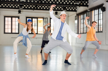 Wall Mural - One young lady and few boys dancing hip-hop dance