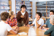 © JackF - Asian schoolgirl talking in front of team of schoolkids during classes in school library