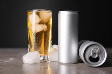 Sticker - Tasty energy drink with ice cubes in glass and aluminium cans on grey table