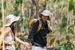 © itchaznong - Happy LGBT Lesbian couple Travelers Hiking with Backpacks in forest Trail. LGBT Lesbian Couple Hikers with backpacks walks in mountains in vacation