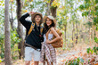 © itchaznong - Happy LGBT Lesbian couple Travelers Hiking with Backpacks in forest Trail. LGBT Lesbian Couple Hikers with backpacks walks in mountains in vacation