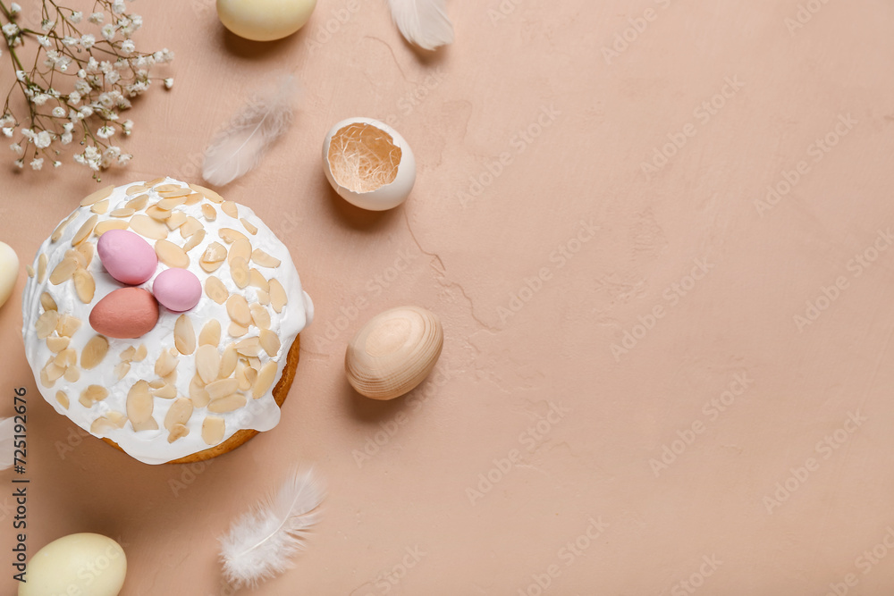 Composition with Easter cake, painted eggs, feathers and gypsophila flowers on beige background