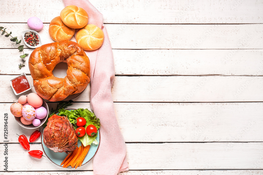 Tasty dishes and painted eggs for Easter dinner on light wooden background
